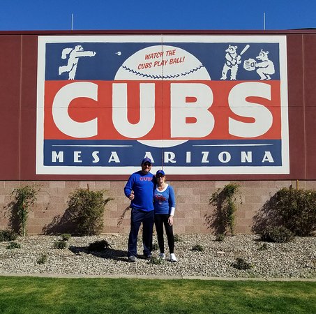 image of a couple posing in front of the Chicago Cubs logo at Sloan Park.